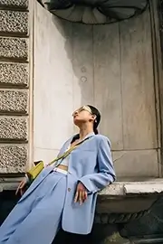 Asian teenager dressed in blue posing on a sculpture