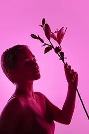 Woman holding a bouquet of flowers on a pink neon background