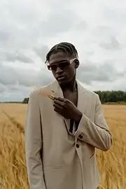 Elegantly dressed African man in a wheat field